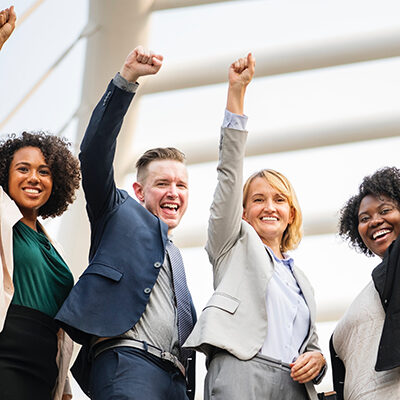 group of people with hands in air and smiling