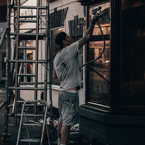 man painting exterior of building