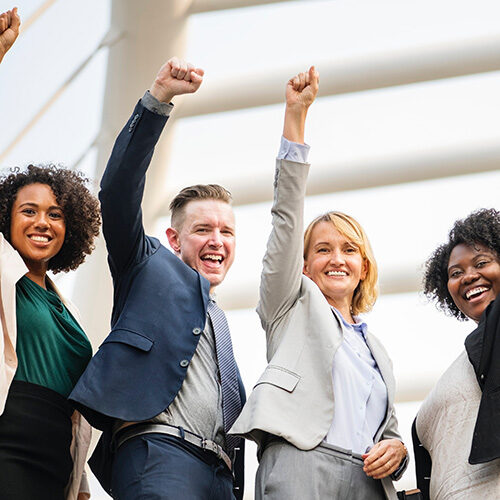 group of people smiling and arm/fists up in the air