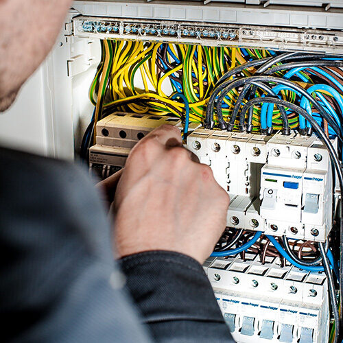 person adjusting wires from electrical box