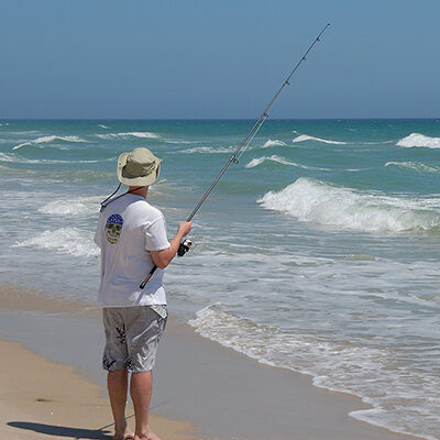 fisherman on beach with waves